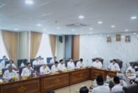 BANDAR LAMPUNG – Universitas Islam Negeri (UIN) Raden Intan Lampung (RIL) menegaskan langkah penajaman program dan keberlanjutan kinerja tahun 2026 melalui penandatanganan kontrak kinerja Indikator Kinerja Utama (IKU) dan penyerahan Rencana Kerja Tahunan (RKT) oleh seluruh pimpinan bersama Rektor, disaksikan para wakil rektor, Senin (04/05/2026) di Ruang Rapat Rektor.Agenda ini merupakan tindak lanjut dari Rapat Kerja Pimpinan (Rakerpim) 19 April 2026. Rekomendasi raker tersebut diterjemahkan kembali dalam arah kebijakan yang lebih operasional, terutama terkait penajaman anggaran, efisiensi, serta fokus program prioritas kampus.Wakil Rektor II UIN Raden Intan Lampung, Prof. Dr. Safari, M.Sos.I, menjelaskan bahwa kebijakan penajaman (efisiensi) anggaran tahun 2026 mengacu pada kebijakan pemerintah pusat tentang penataan belanja satuan kerja serta rekomendasi rapat kerja 19 April 2026.Ia menegaskan, anggaran 2026 diarahkan pada program-program strategis yang memiliki dampak langsung terhadap target universitas“Anggaran ini menjadi stimulan. Karena itu harus difokuskan pada kegiatan prioritas strategis,” ujar Prof. Safari.Program prioritas yang dimaksud antara lain mendukung pendirian Fakultas Kedokteran, menunjang upaya mempertahankan akreditasi perguruan tinggi (APT) Unggul, termasuk kebutuhan sertifikasi dan pemeringkatan internasional, serta peningkatan jumlah mahasiswa baru.Selain itu, rapat juga membahas penyatuan gedung pascasarjana agar fasilitas yang ada dapat terintegrasi dan lebih efisien.Di bidang efisiensi, Prof. Safari meminta seluruh unit melaporkan dampak nyata dari kebijakan penghematan, terutama terkait penggunaan listrik dan air serta optimalisasi fasilitas kampus menjadi bagian dari kebijakan baru pola kerja.“Harus ada statistiknya. Jangan hanya kebijakan kerja dari rumah, tapi tidak terukur dampaknya. Tujuan pola kerja itu untuk penghematan energi,” ujarnya.Sementara itu, Rektor UIN Raden Intan Lampung Prof. H. Wan Jamaluddin Z, M.Ag., Ph.D. mengingatkan seluruh pimpinan agar tetap menjaga semangat kerja di tengah kondisi anggaran yang mengalami penyesuaian.“Apapun itu kita tetap harus bersyukur kepada Allah SWT. Saya berharap kita semua tetap bisa menjaga, memelihara, bahkan meningkatkan semangat kinerja kita,” kata Rektor.Ia menegaskan, hak-hak dasar aparatur tidak terganggu. “Gaji, tunjangan kinerja, sertifikasi insya Allah tetap berjalan,” ujarnya.Karena itu, menurut Rektor, penyesuaian anggaran tidak boleh menjadi alasan menurunnya kinerja. Ia mengajak seluruh sivitas akademika mengikuti arahan pemerintah terkait pola kerja baru dengan semangat hidup lebih sederhana.Rektor menilai semangat efisiensi harus tercermin dalam kehidupan kampus sehari-hari, mulai dari penghematan listrik, air, hingga penggunaan kendaraan operasional.Rektor melanjutkan, kampus perlu mengoptimalkan aset serta membuka peluang sumber pendanaan eksternal yang dapat menopang pelaksanaan tridarma perguruan tinggi dan pengembangan kampus.Ia juga menaruh perhatian pada mahasiswa melalui skema beasiswa dan dukungan pembiayaan studi.“Tingkat kepedulian kita kepada mahasiswa bisa disiasati melalui reward atas capaian mereka, misalnya bantuan UKT yang langsung dibayarkan untuk mahasiswa yang bersangkutan. Itu lebih terukur dan mudah diawasi,” ujarnya.Rektor juga mengimbau pimpinan yang memiliki jejaring dengan dunia usaha, industri, dan pihak eksternal lainnya agar ikut membantu membuka peluang dukungan bagi mahasiswa dan alumni, terutama untuk membantu penyelesaian studi dan keberlanjutan pengabdian pasca studi.Dalam kesempatan itu, Rektor kembali menegaskan pentingnya soliditas tim kerja.“Kita membutuhkan monoloyalitas dan soliditas tim kerja. Jangan mudah terpengaruh isu ini dan itu. Dengan tim baru ini saya menaruh kepercayaan yang sangat besar,” katanya.Prof Wan mengingatkan bahwa tantangan akreditasi dua tahun ke depan tidak ringan. Karena itu, seluruh unit diminta mulai menyiapkan dokumen berbasis data faktual sejak sekarang.“Kalau dicicil dari sekarang, dua tahun ke depan seluruh kebutuhan dokumen sudah siap,” ujarnya.Rektor juga menaruh harapan pada tim baru agar menghadirkan terobosan-terobosan baru bagi kemajuan UIN Raden Intan Lampung.“Apapun situasi dan kondisi yang kita hadapi, kita harus siap. Optimisme harus tetap tinggi. Alhamdulillah UIN Raden Intan Lampung masih bisa beradaptasi,” katanya.Kegiatan kemudian dilanjutkan dengan penandatanganan Kontrak Kinerja IKU dan penyerahan RKT Tahun 2026 oleh seluruh pimpinan kepada Rektor, disaksikan para Wakil Rektor.Langkah penajaman program, efisiensi anggaran, dan penguatan kinerja tahun 2026 ini juga menjadi bagian dari keberlanjutan arah kepemimpinan Rektor UIN Raden Intan Lampung dalam periode Ber-ISI Mendunia, yang menekankan penguatan institusi, daya saing internasional, serta keberlanjutan pengembangan kampus.[De]