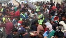 Warga Palestina menerima makanan gratis dari pusat distribusi makanan di Gaza City . [Xin]