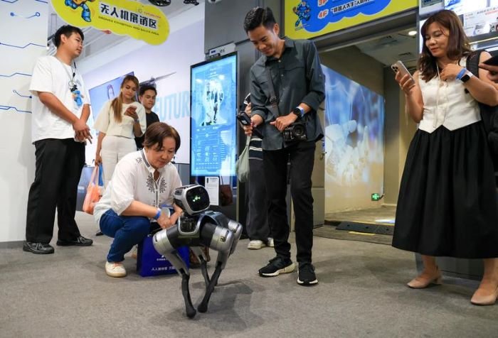 
Jurnalis dan pemengaruh media sosial dari negara-negara ASEAN berinteraksi dengan robot anjing di zona robotika di Shenzhen, Provinsi Guangdong, China selatan, pada 29 Juli 2026. [Xin]