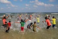 Anak-anak bermain dalam sebuah acara renang yang diikuti oleh sekitar 1.300 anak di sebuah pantai di Khan Younis, Jalur Gaza selatan, pada 21 Agustus 2026. (Xinhua)