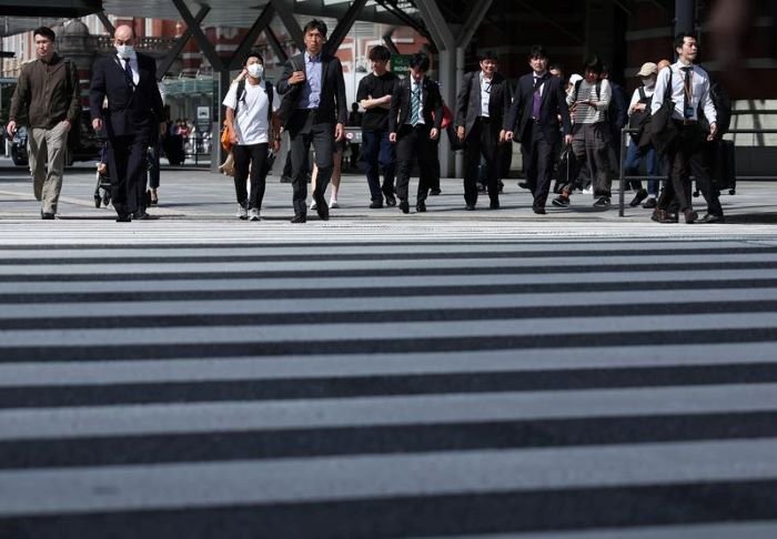 Pejalan kaki menyeberangi jalan di dekat Stasiun Tokyo di Tokyo, Jepang [Xin]