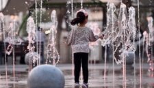 Seorang anak bermain di antara pancuran air di Kuwait City, Kuwait. (Xinhua)