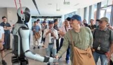 Foto yang diabadikan pada 7 Agustus 2026 ini menunjukkan seorang dosen kejuruan asal Indonesia berjabat tangan dengan sebuah robot humanoid saat berkunjung ke sebuah perusahaan AI berwujud yang terletak di Kota Liuzhou, Daerah Otonom Etnis Zhuang Guangxi, Tiongkok selatan. (Xinhua)