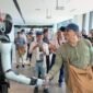 Foto yang diabadikan pada 7 Agustus 2026 ini menunjukkan seorang dosen kejuruan asal Indonesia berjabat tangan dengan sebuah robot humanoid saat berkunjung ke sebuah perusahaan AI berwujud yang terletak di Kota Liuzhou, Daerah Otonom Etnis Zhuang Guangxi, Tiongkok selatan. (Xinhua)