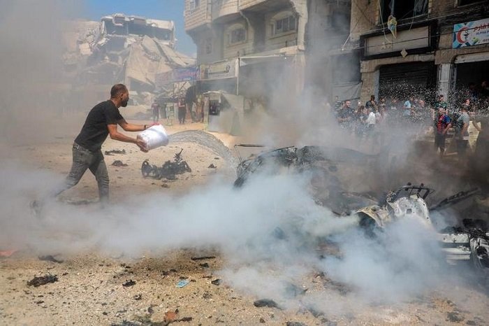 Seorang warga Palestina memadamkan api pada sebuah kendaraan yang hancur akibat serangan drone Israel di kawasan permukiman Tel al-Hawa, Gaza City, pada 31 Agustus 2026. (Xinhua)