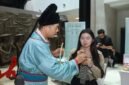 Seorang staf dari Tiongkok sedang membimbing warga Indonesia memainkan replika Suling Tulang Jiahu, di Jakarta. (Xinhua)