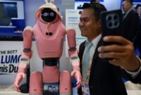 Seorang pengunjung berswafoto bersama robot dalam Forum Media Asia-Pasifik di Shenzhen, Provinsi Guangdong, Tiongkok selatan, pada 5 September 2026. (Xinhua)