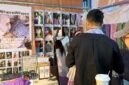 Foto dokumentasi ini menunjukkan seorang wisatawan menjajal syal batik di sebuah stan pasar rakyat di Chongqing, Tiongkok barat daya. (Xinhua)