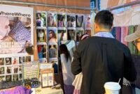
Foto dokumentasi ini menunjukkan seorang wisatawan menjajal syal batik di sebuah stan pasar rakyat di Chongqing, Tiongkok barat daya. (Xinhua)