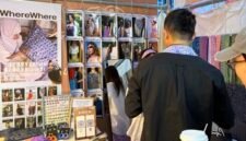 Foto dokumentasi ini menunjukkan seorang wisatawan menjajal syal batik di sebuah stan pasar rakyat di Chongqing, Tiongkok barat daya. (Xinhua)