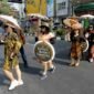 SEJUMLAH perempuan yang mengenakan baju batik dan membawa payung bermotif batik melakukan peragaan busana saat peringatan Hari Batik Nasional di sebuah penyeberangan jalan di sekitar lampu lalu lintas Jalan Slamet Riyadi di Kota Solo, Provinsi Jawa Tengah, pada 2 Oktober 2026. (Xinhua)