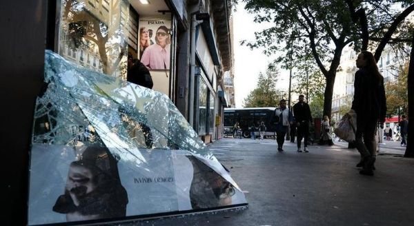 Orang-orang berjalan melewati sebuah toko yang rusak akibat aksi unjuk rasa di Paris, Francis, pada 18 Oktober 2026. Presiden Francis Emmanuel Macron pada Minggu (18/10) berjanji akan menempuh langkah hukum terhadap para pelaku kekerasan dalam aksi unjuk rasa yang berlangsung di berbagai penjuru negara itu pada Sabtu (17/10). (Xinhua)