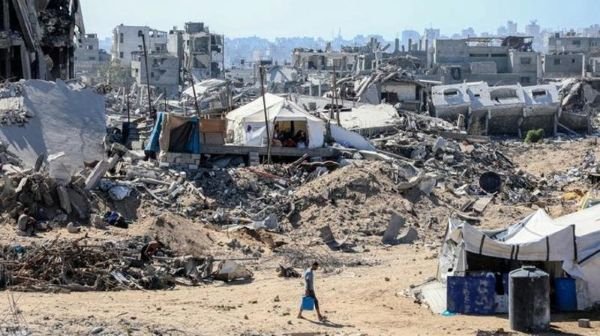 Seorang warga Palestina terlihat di sebuah jalan yang dipenuhi bangunan yang hancur di kamp pengungsi Jabalia, Jalur Gaza utara, pada 27 Oktober 2025. (Xinhua)
