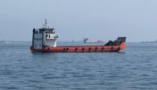 Foto yang diabadikan menggunakan ponsel ini memperlihatkan kapal-kapal niaga yang terdampar di perairan Selat Hormuz di dekat Khasab, sebuah kota kecil di Oman utara, pada 29 Mei 2026. (Xinhua)