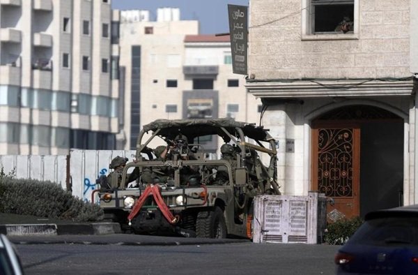 Sebuah kendaraan militer Israel berpatroli saat operasi militer di Kota Hebron, Tepi Barat, pada 25 Oktober 2026. (Xinhua)