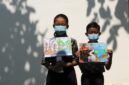 Murid sekolah dasar (SD) terlihat mengenakan masker dan memegang poster bertema kampanye stop kebakaran hutan dan lahan (karhutla) yang mereka gambar menggunakan krayon dan pensil warna di SDN Nayu Barat 1, Nusukan, Surakarta, Provinsi Jawa Tengah, pada 21 Oktober 2026. (Xinhua)
