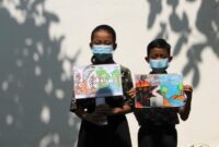Murid sekolah dasar (SD) terlihat mengenakan masker dan memegang poster bertema kampanye stop kebakaran hutan dan lahan (karhutla) yang mereka gambar menggunakan krayon dan pensil warna di SDN Nayu Barat 1, Nusukan, Surakarta, Provinsi Jawa Tengah, pada 21 Oktober 2026. (Xinhua)

