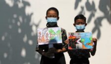Murid sekolah dasar (SD) terlihat mengenakan masker dan memegang poster bertema kampanye stop kebakaran hutan dan lahan (karhutla) yang mereka gambar menggunakan krayon dan pensil warna di SDN Nayu Barat 1, Nusukan, Surakarta, Provinsi Jawa Tengah, pada 21 Oktober 2026. (Xinhua)
