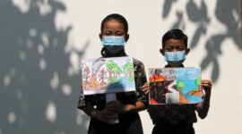 Murid sekolah dasar (SD) terlihat mengenakan masker dan memegang poster bertema kampanye stop kebakaran hutan dan lahan (karhutla) yang mereka gambar menggunakan krayon dan pensil warna di SDN Nayu Barat 1, Nusukan, Surakarta, Provinsi Jawa Tengah, pada 21 Oktober 2026. (Xinhua)
