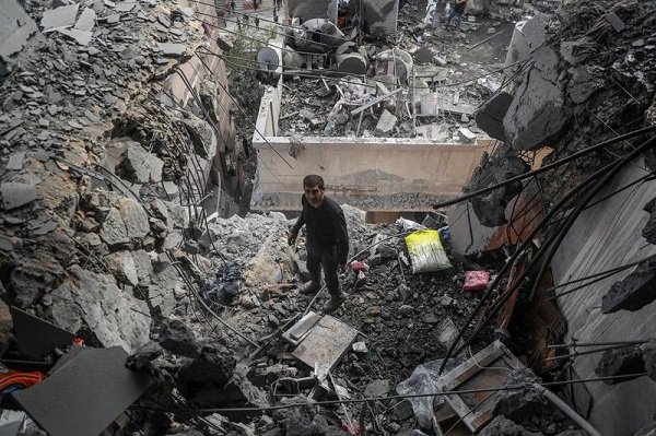 Seorang pria Palestina memeriksa sebuah gedung apartemen yang hancur setelah serangan udara Israel di Gaza City pada 24 April 2025. (Xinhua)
