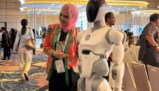 Seorang peserta Danantara Technology Innovation Investment Forum (DTIIF) 2026 berfoto dengan salah satu robot buatan AI² Robotics di Jakarta pada 28 Oktober 2026. (Xinhua/Ni Luh Anggela De Merici S.)