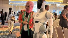 Seorang peserta Danantara Technology Innovation Investment Forum (DTIIF) 2026 berfoto dengan salah satu robot buatan AI² Robotics di Jakarta pada 28 Oktober 2026. (Xinhua/Ni Luh Anggela De Merici S.)
